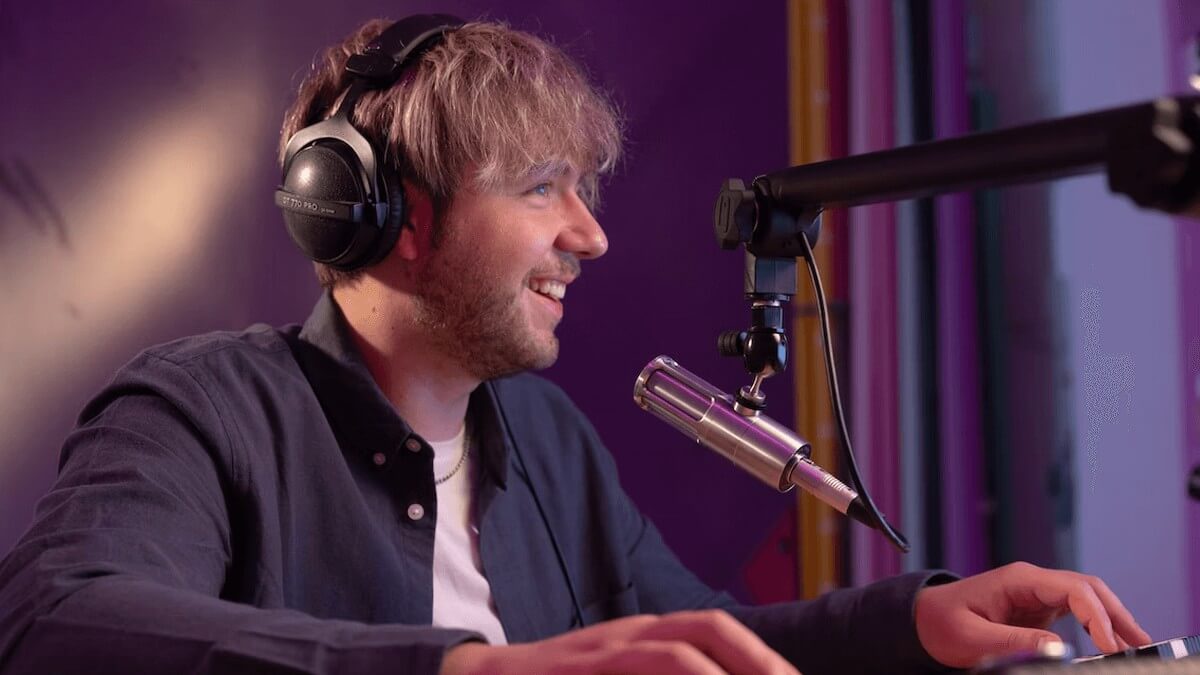 a male content creator speaks into a microphone for a youtube video