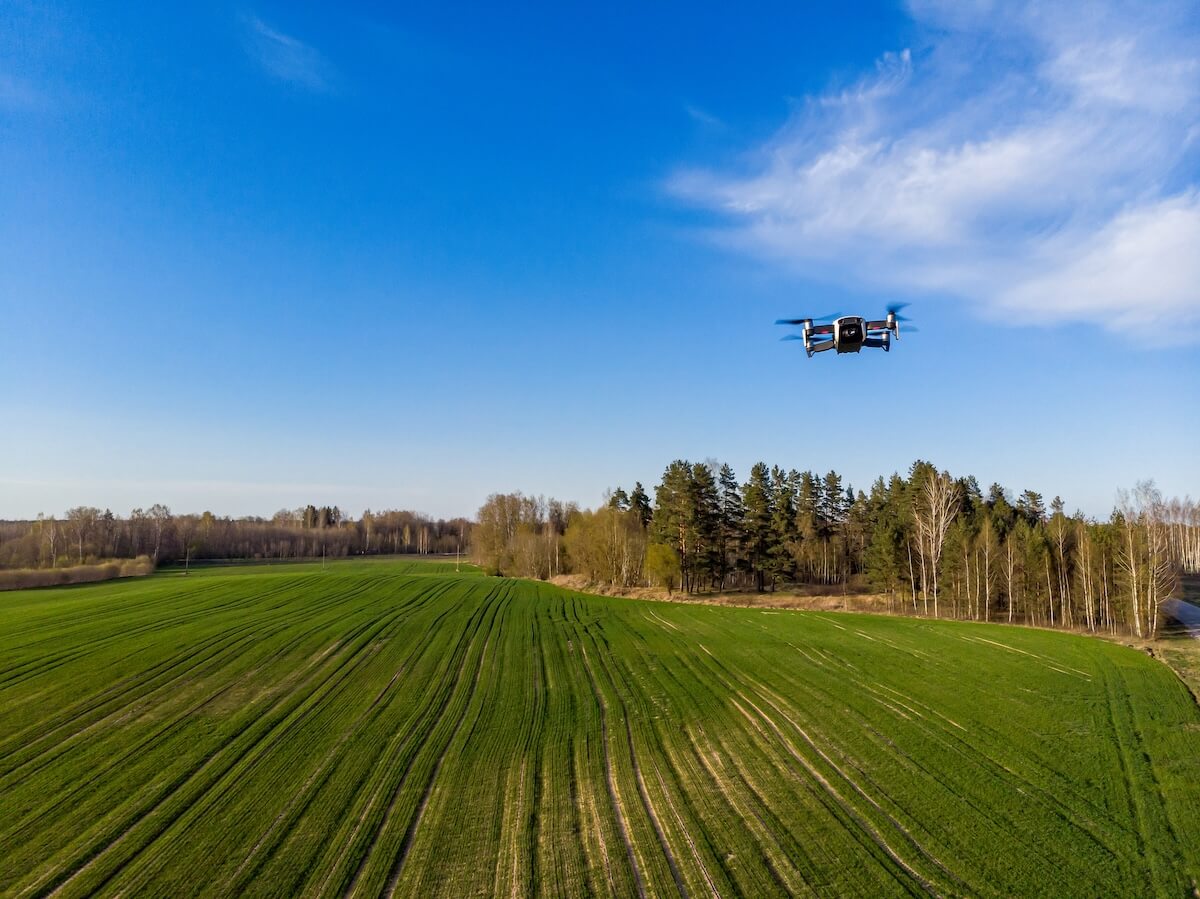 Drone imagery over green crop field for crop intelligence and yield analysis.